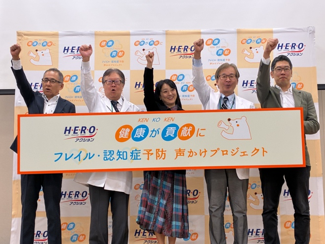 2026年10月22日、フレイル・認知症予防声かけプロジェクトの始動式で登壇者5人が看板を掲げる様子